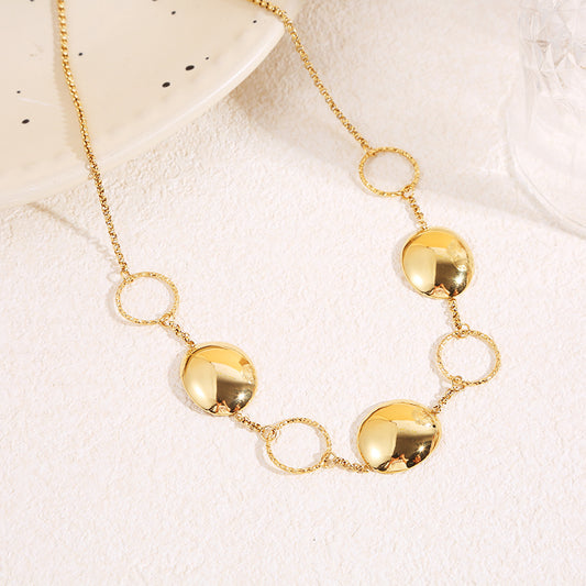 Collier à chaîne fine dorée alternant anneaux texturés et pastilles bombées finition miroir