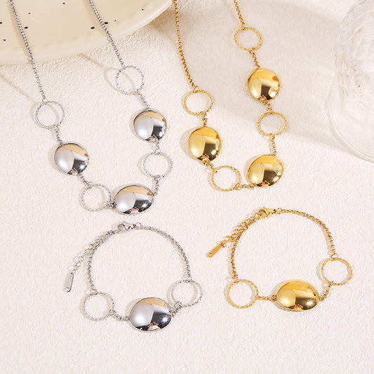 Collier à chaîne fine dorée alternant anneaux texturés et pastilles bombées finition miroir