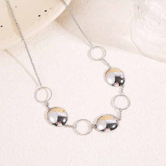 Collier à chaîne fine argentée alternant anneaux texturés et pastilles bombées finition miroir