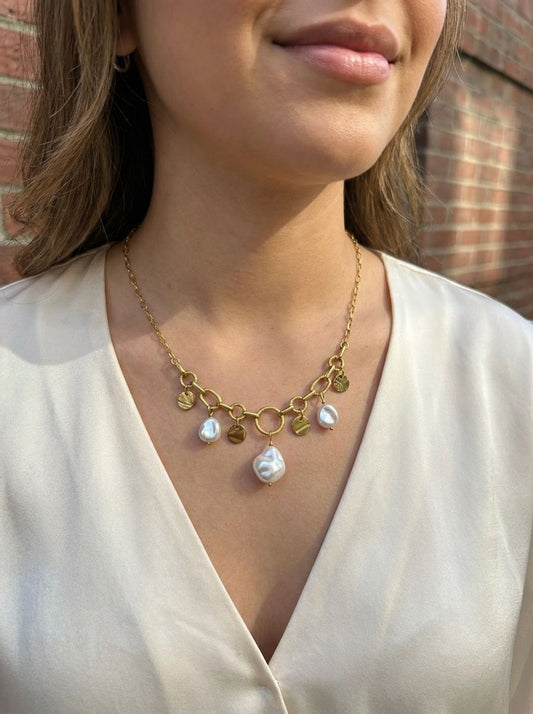 Collier à maillons dorés alternant anneaux texturés et barres lisses, agrémenté de pendentifs médaillons martelés et de perles blanches irrégulières