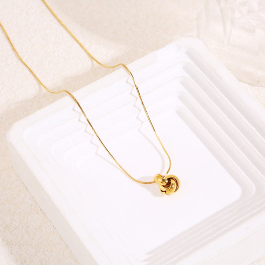 Collier chaîne serpent fine dorée avec pendentif nœud sculpté en relief