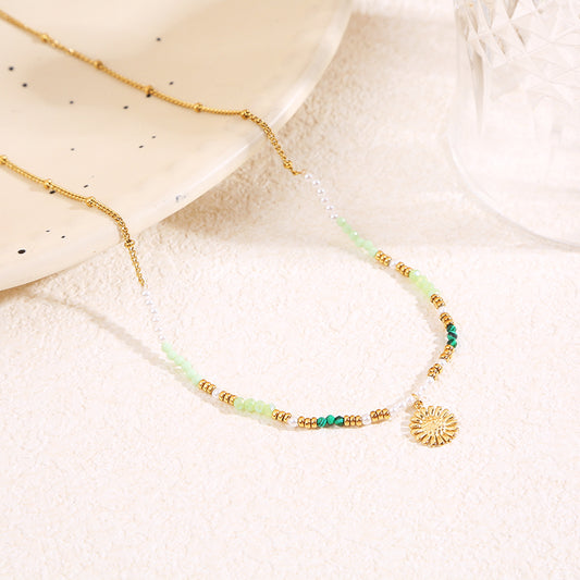 Collier doré cristaux verts pendentif marguerite