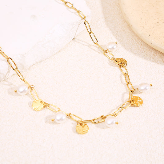 Collier à chaîne dorée à maillons longs, orné de pendentifs médaillons martelés et de perles blanches pendantes