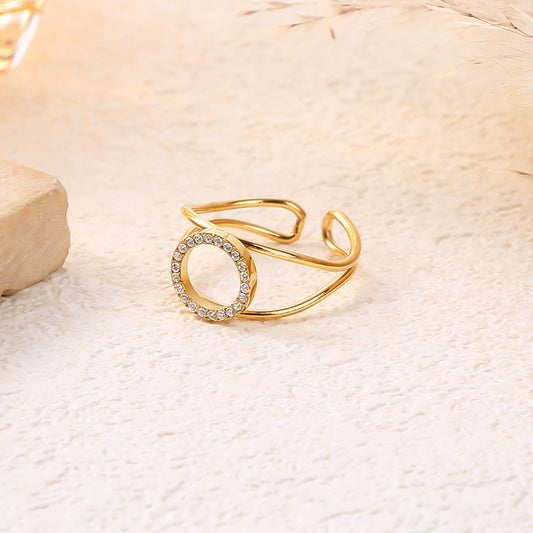 Bague dorée ajustable avec cercle central strassé et courbure structurée