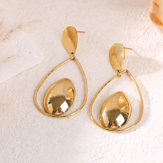 Boucles d'oreilles pendantes dorées forme goutte ajourée médaillon central bombé effet miroir
