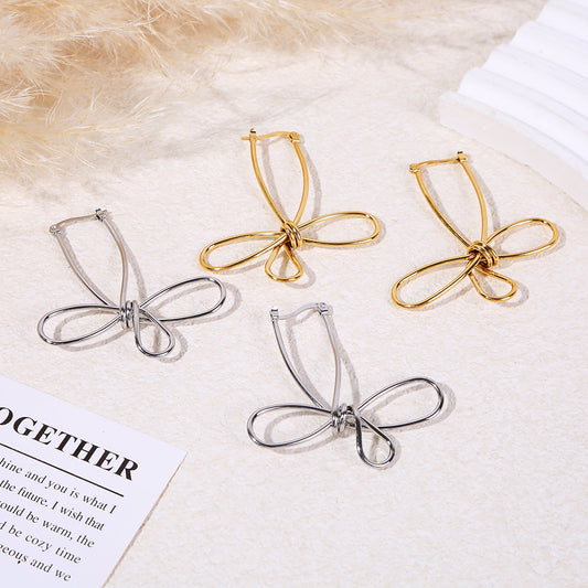 Boucles d'oreilles pendantes argentées fil métal formant un nœud papillon minimaliste