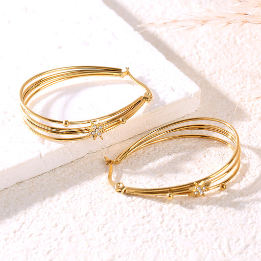 Boucles d'oreilles dorées à 4 anneaux ovales reliés ornées d'étoiles strassées