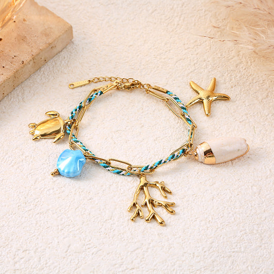Bracelet chaîne dorée cordon bleu-vert charms tortue corail étoile de mer
