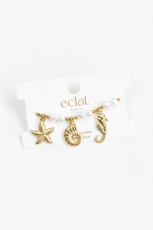 Bracelet doré avec perles structurées et breloques marins