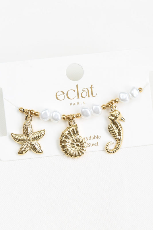 Bracelet doré avec perles structurées et breloques marins