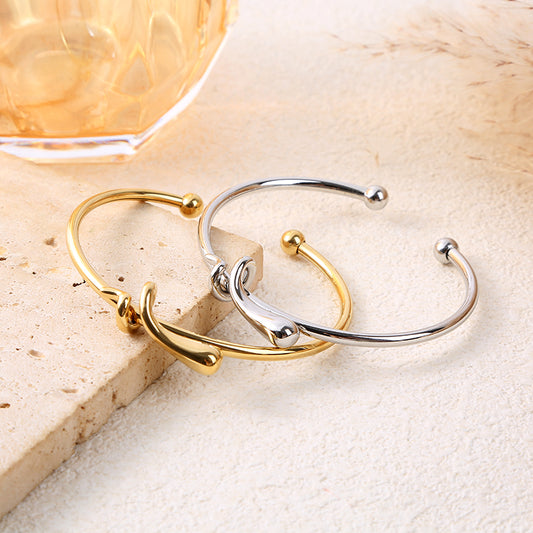 Bracelet jonc ajustable doré avec nœud central sculpté et extrémités boule