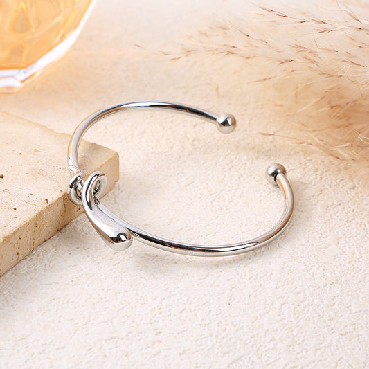 Bracelet jonc ajustable argenté avec nœud central sculpté et extrémités boule