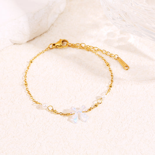 Bracelet chaîne dorée avec perle et nœud blanc