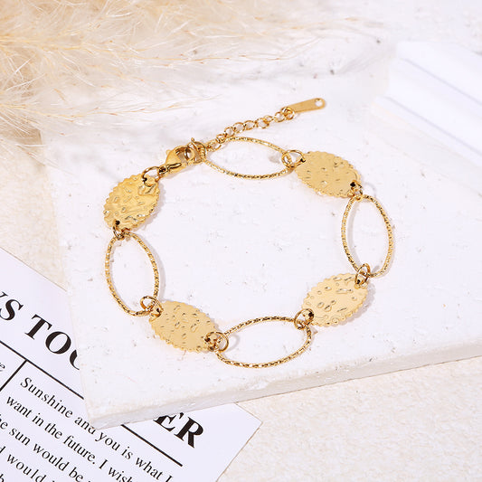 Bracelet doré alternant maillons ovales texturés et médaillons ronds martelés