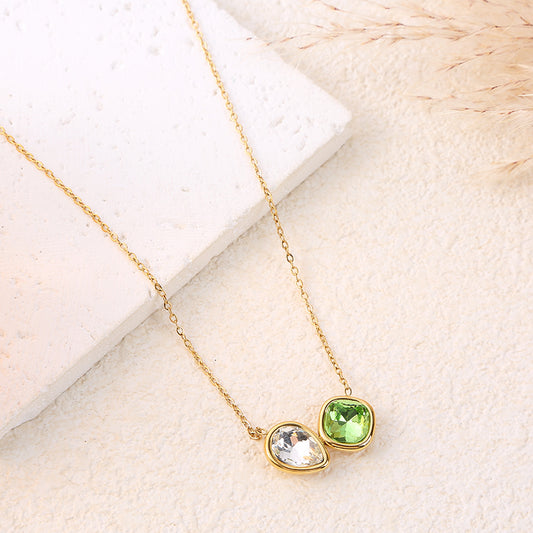 Collier chaîne dorée avec cristal en forme de losange arrondi vert et goutte blanche