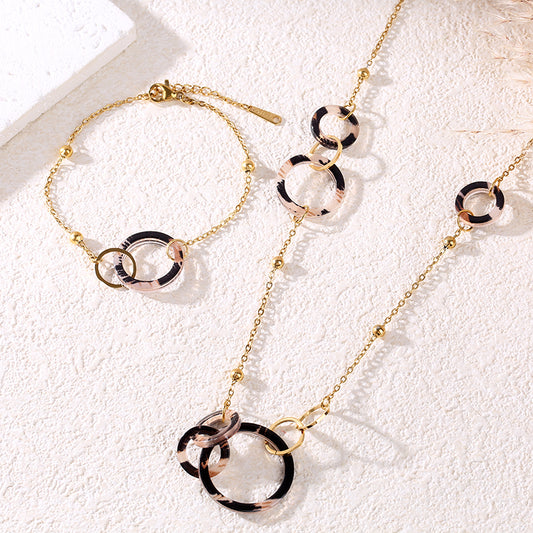 Collier sautoir chaîne dorée orné d'anneaux ronds aux motifs animaliers et dorés