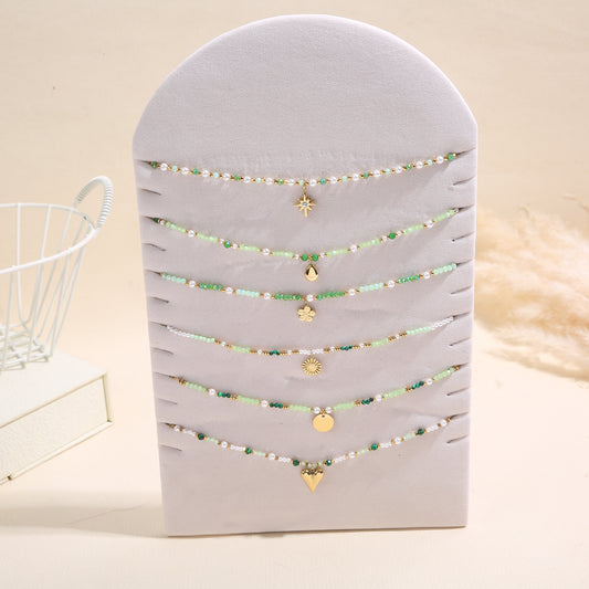 Lot de 6 colliers pendentifs dorés nuances de perles sur présentoir