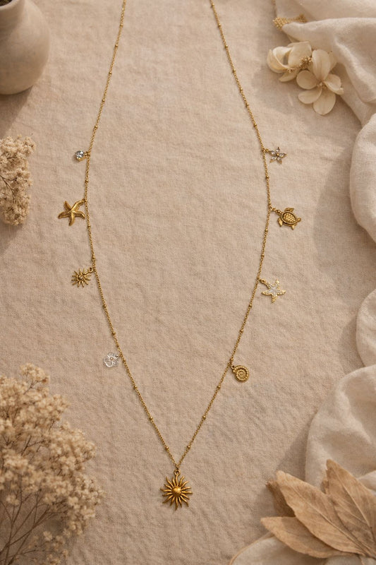 Collier sautoir fin doré à charms soleil et marins
