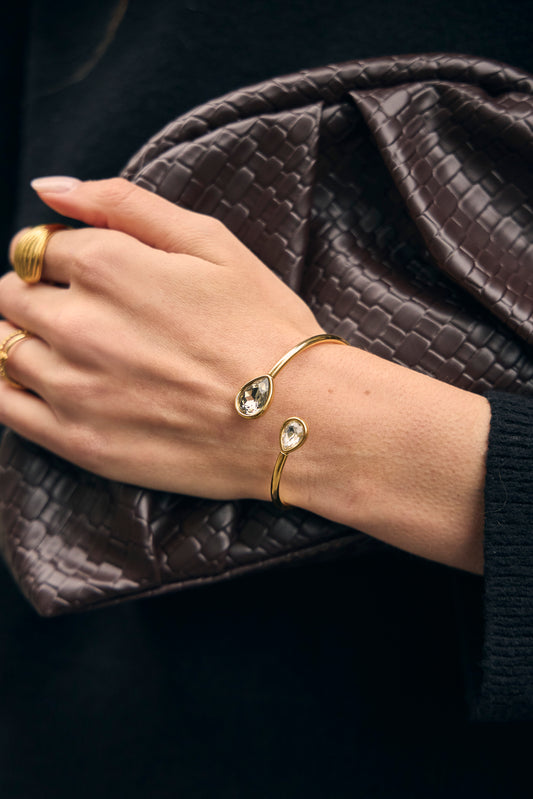 Bracelet manchette amovible dorée ouvert par l'avant avec cristaux de verres en goutte blanc et gris