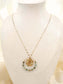 Long necklace with round pendant and green pearls