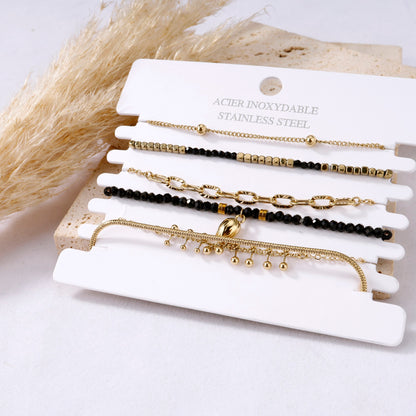 Multiple black bracelets with stones