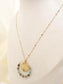 Long necklace with round pendant and green pearls