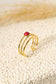 Triple line golden ring with red stone