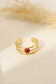 Triple line golden ring with red stone