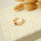 Triple line golden ring with red stone