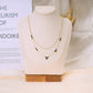 Collier double chaîne pierres vertes dorée